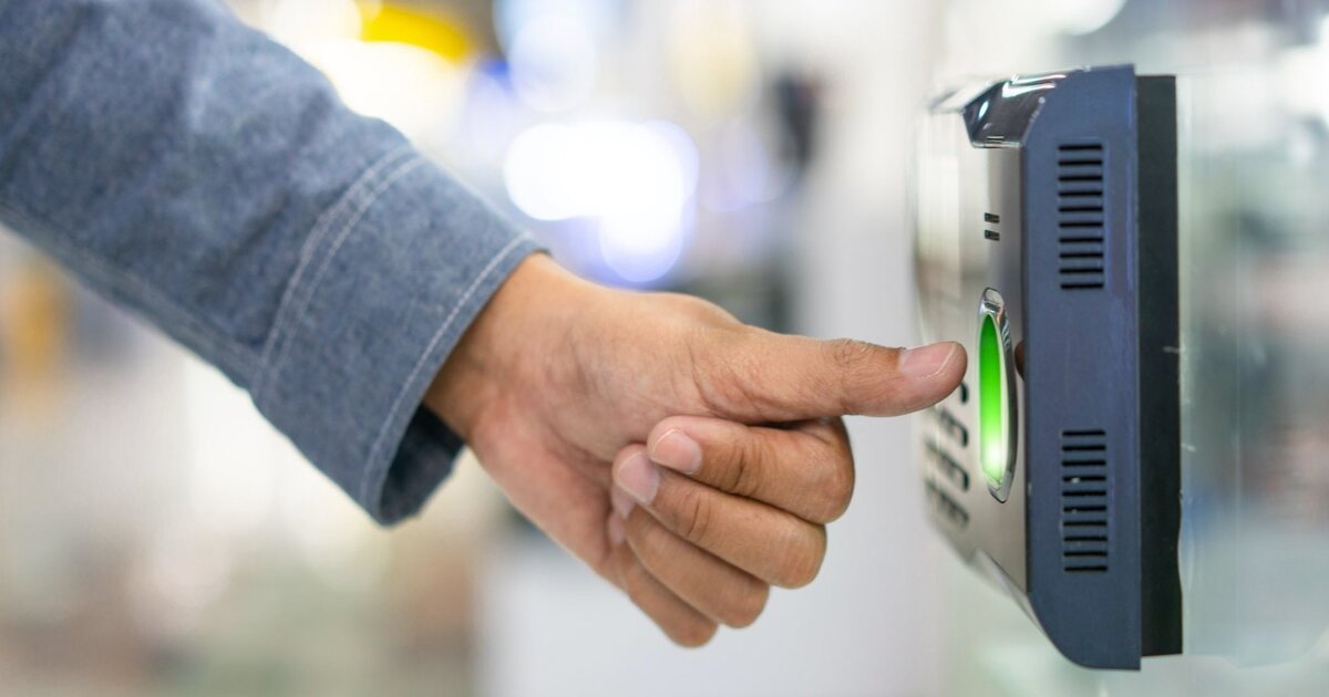 Relógio de ponto digital com trabalhador a registar entrada